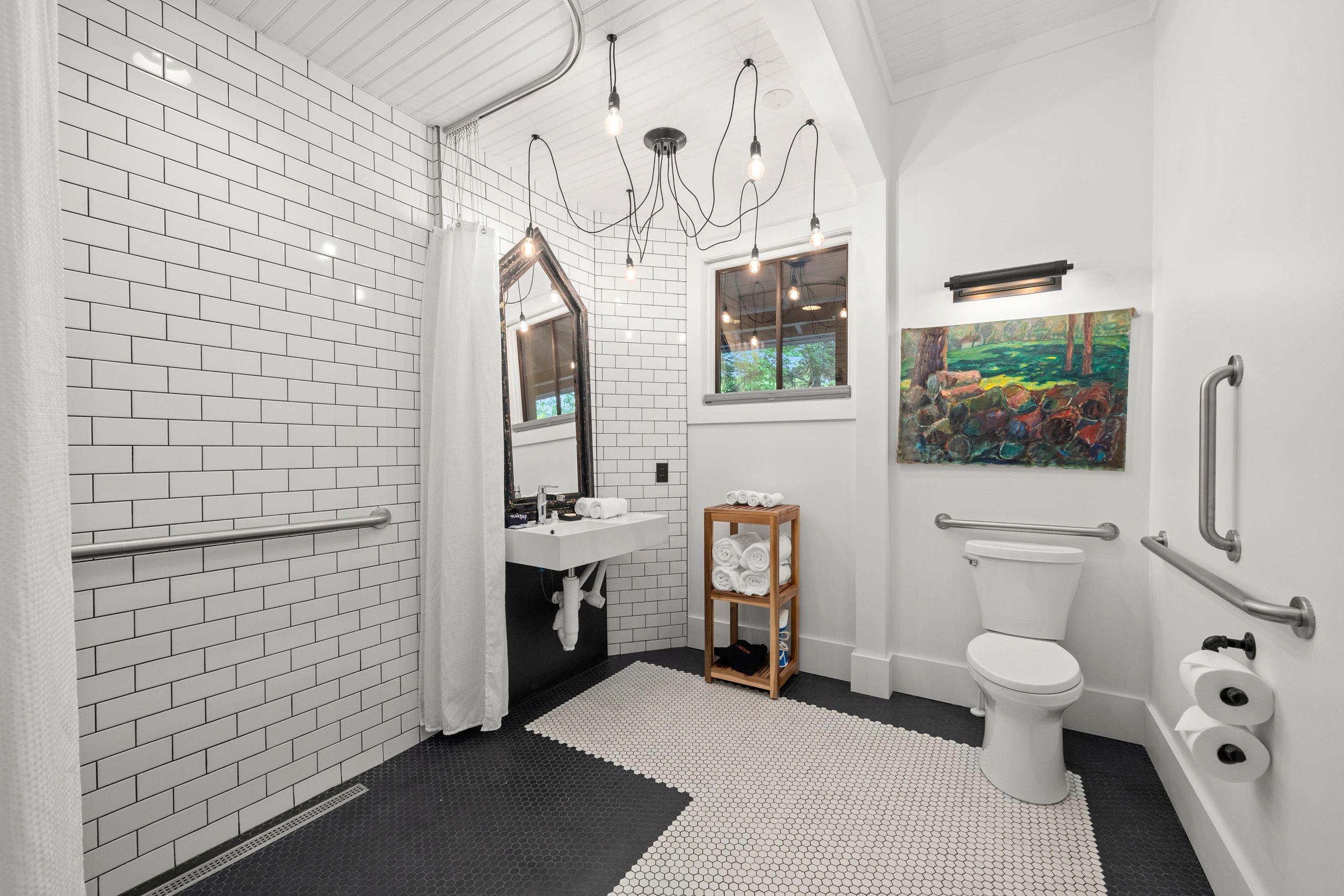 Modern accessible bathroom with white subway tiles and black accents